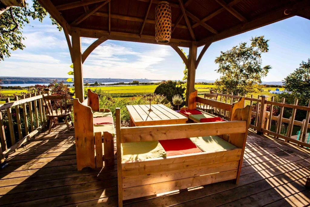 Terrasse en bois ouverte sur une vue panoramique de l’Île d’Orléans